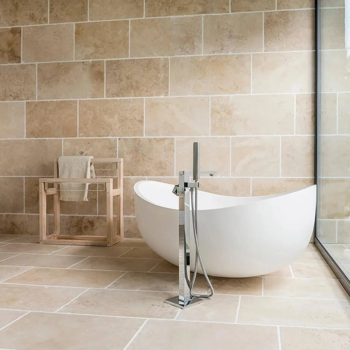 Baño con piso y pared de mármol travertino